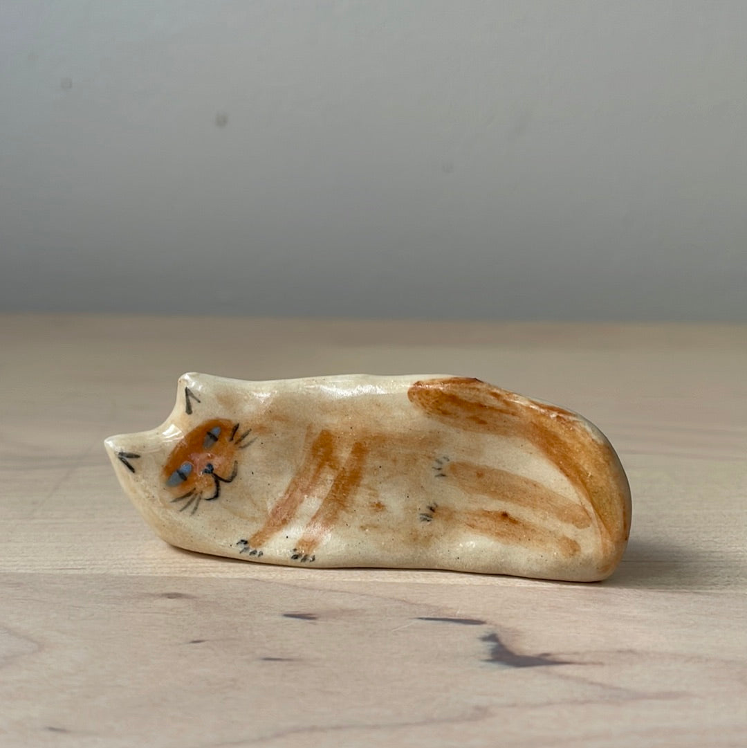 Ceramic: Beige and blue-eyed kitty lying on the side
