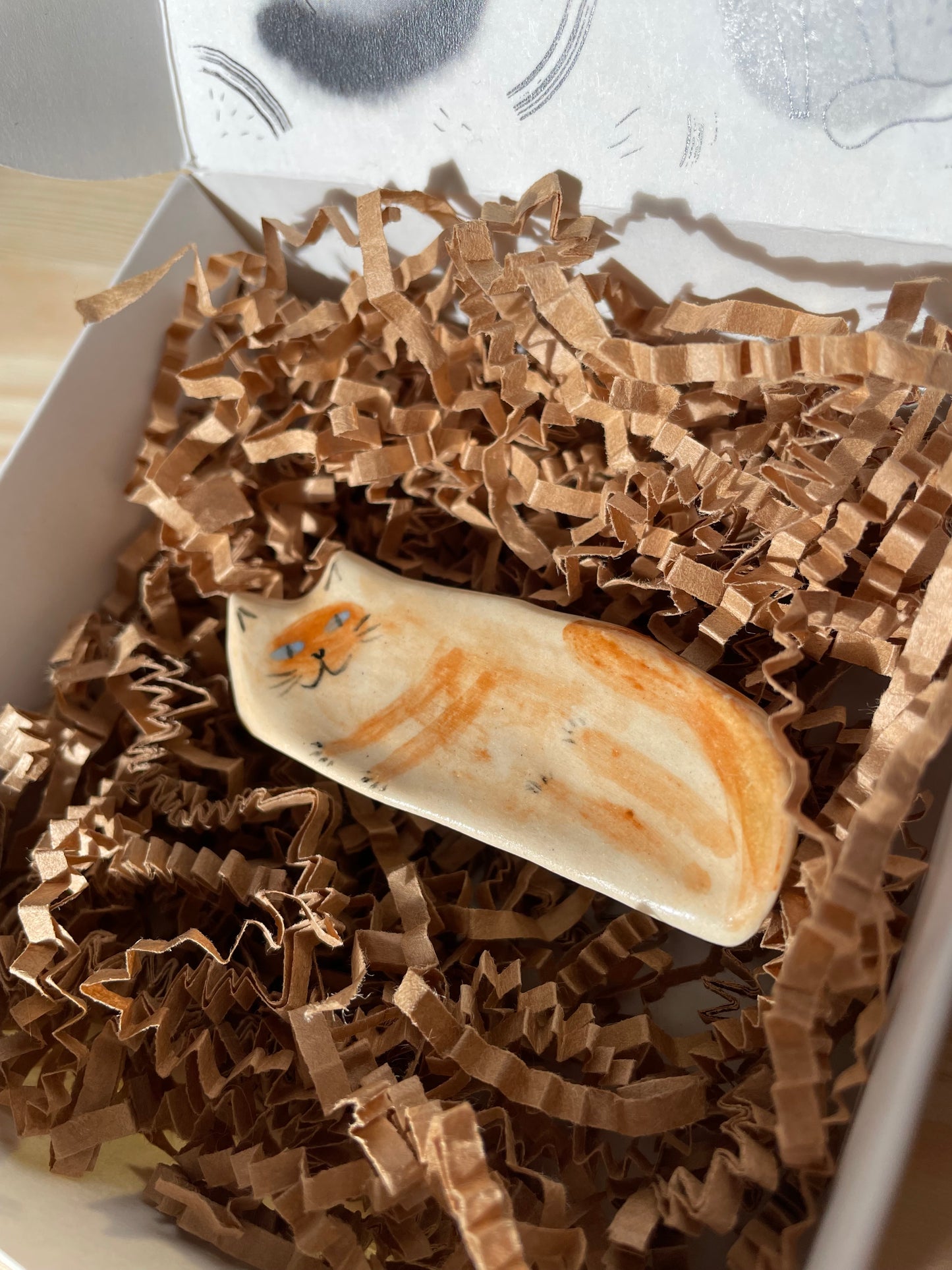 Ceramic: Beige and blue-eyed kitty lying on the side