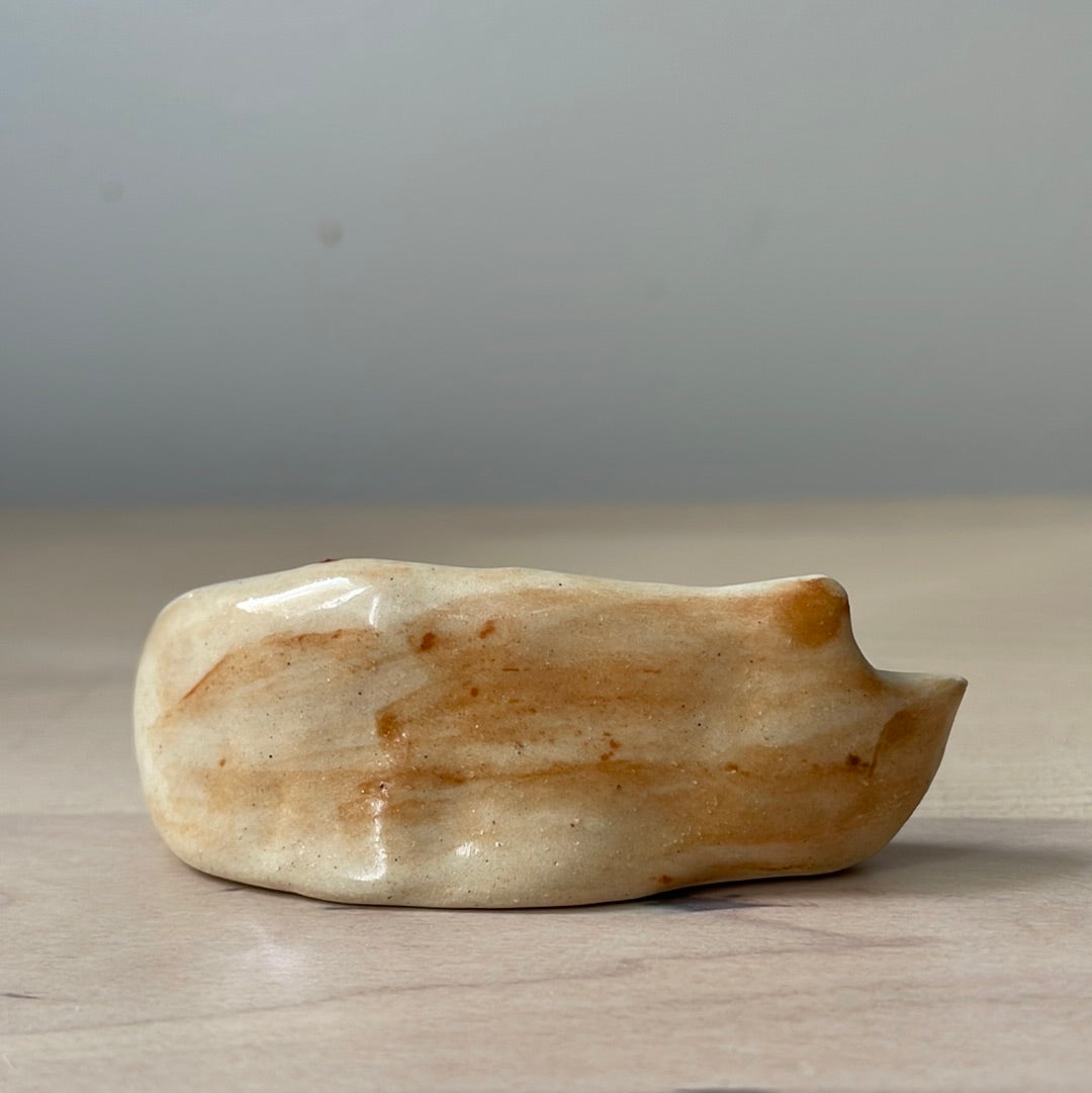 Ceramic: Beige and blue-eyed kitty lying on the side