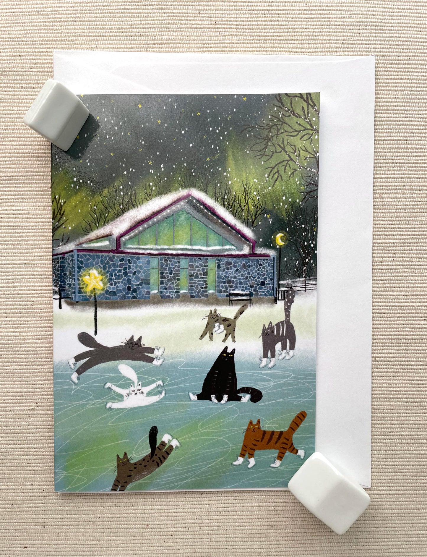 Carte de vœux verticale : Chats patinant sur glace, scène hivernale fantaisiste