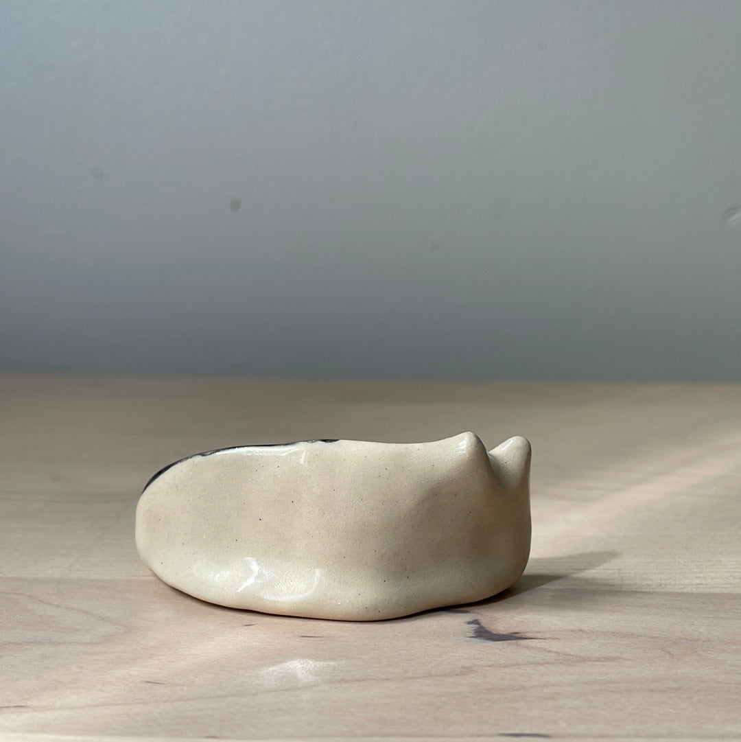 White and black kitty lying on the side: Handmade ceramic cat figurine