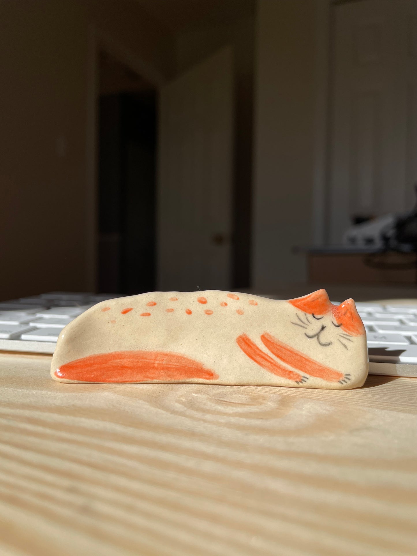 Chat blanc et orange couché sur le côté : Figurine de chat en céramique faite à la main