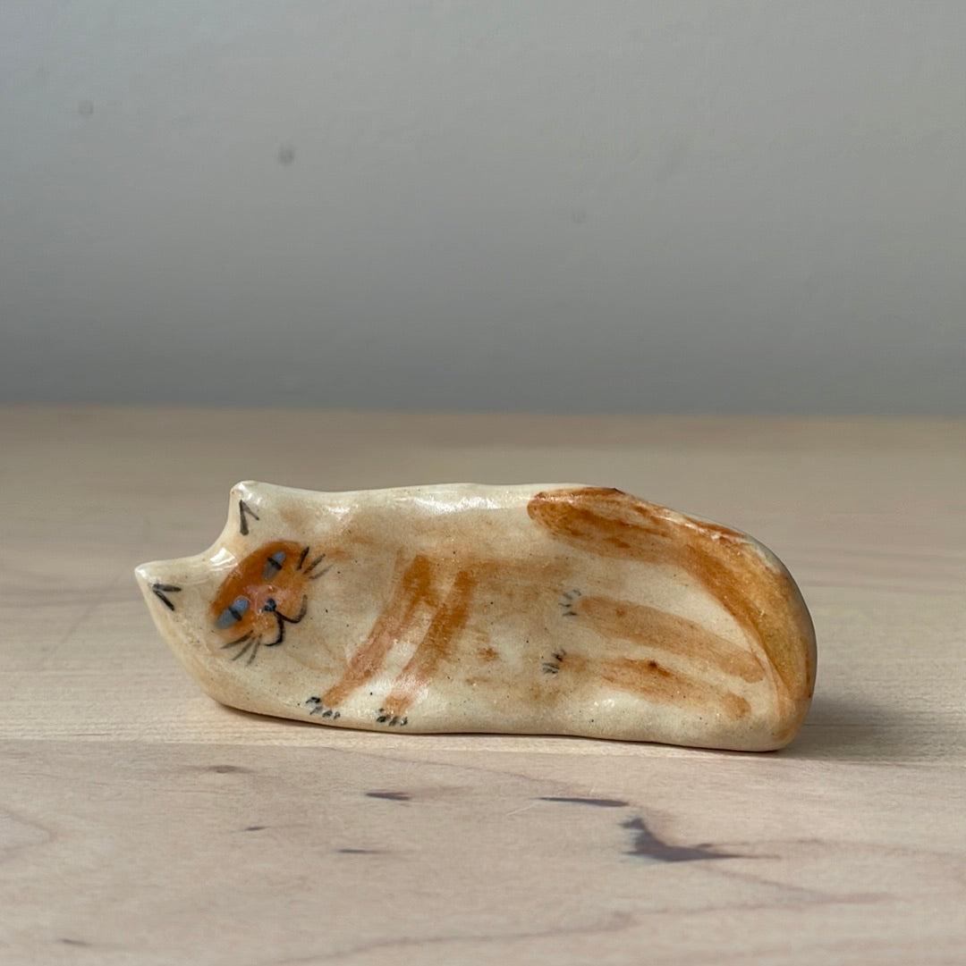 Chaton beige et yeux bleus couché sur le côté : Figurine de chat en céramique faite à la main