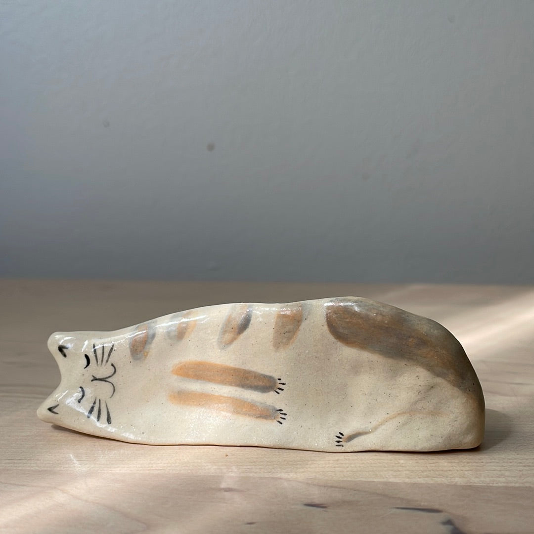 White kitty with brownish stripes lying on the side: Handmade ceramic cat figurine