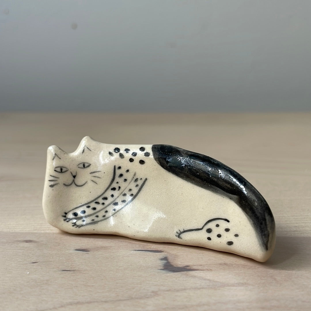 White and black kitty lying on the side: Handmade ceramic cat figurine