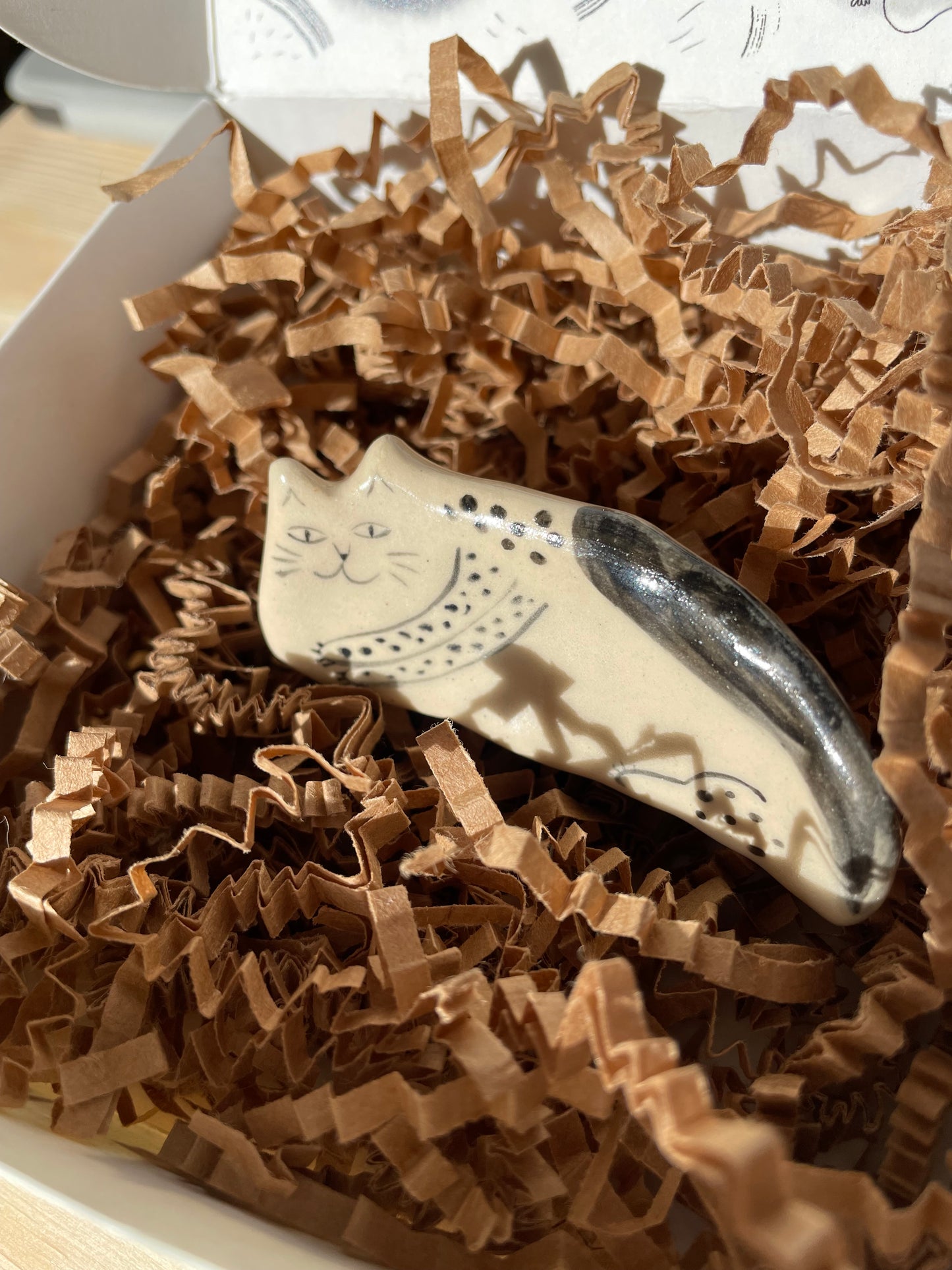 White and black kitty lying on the side: Handmade ceramic cat figurine