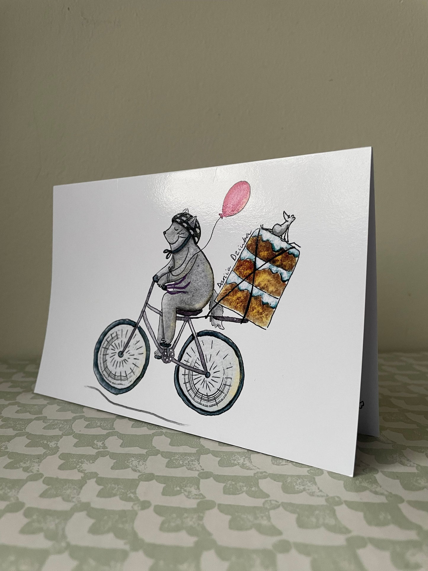 Chat faisant du vélo avec un gâteau : Carte de vœux