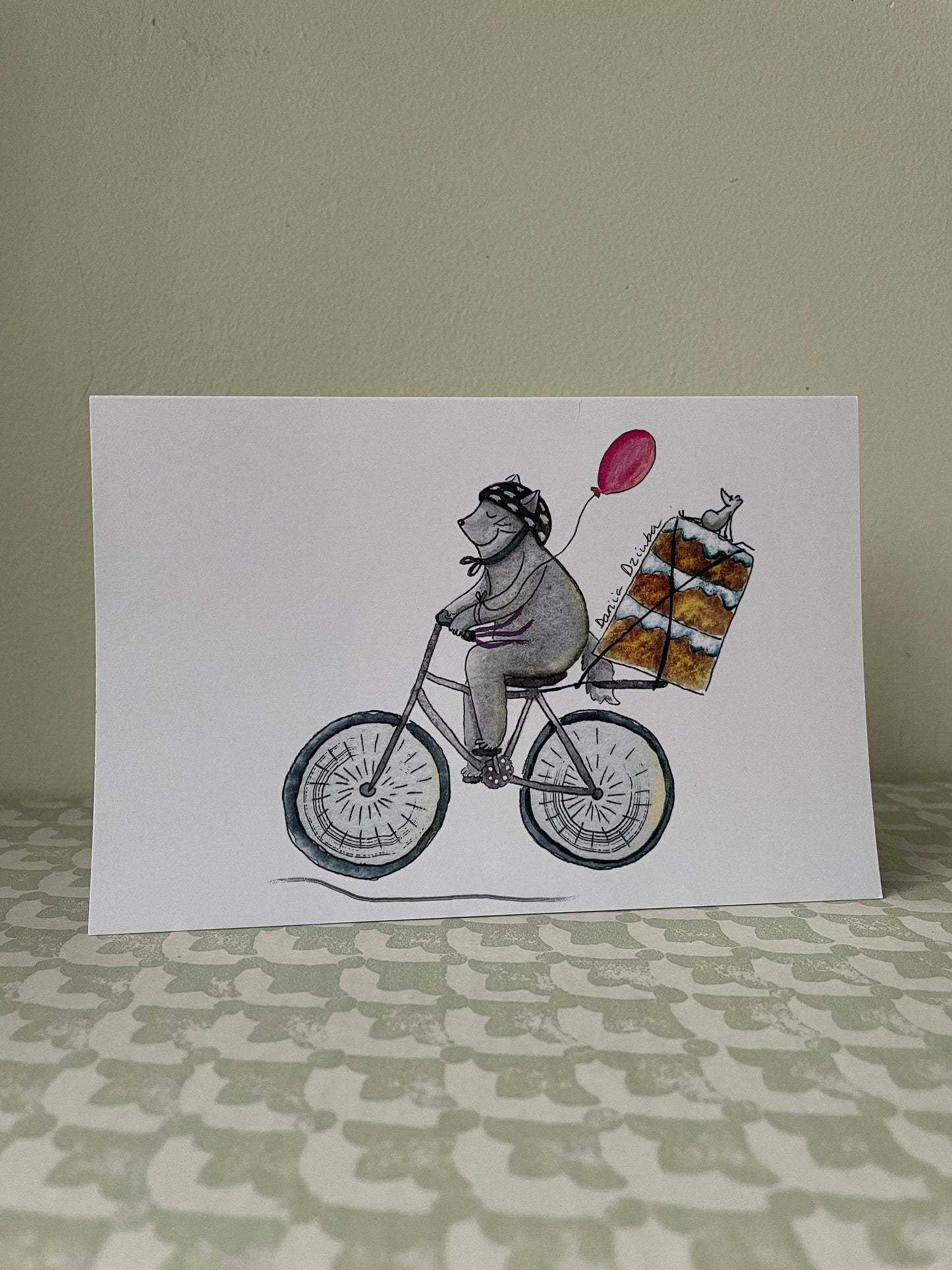 Chat faisant du vélo avec un gâteau : Carte de vœux