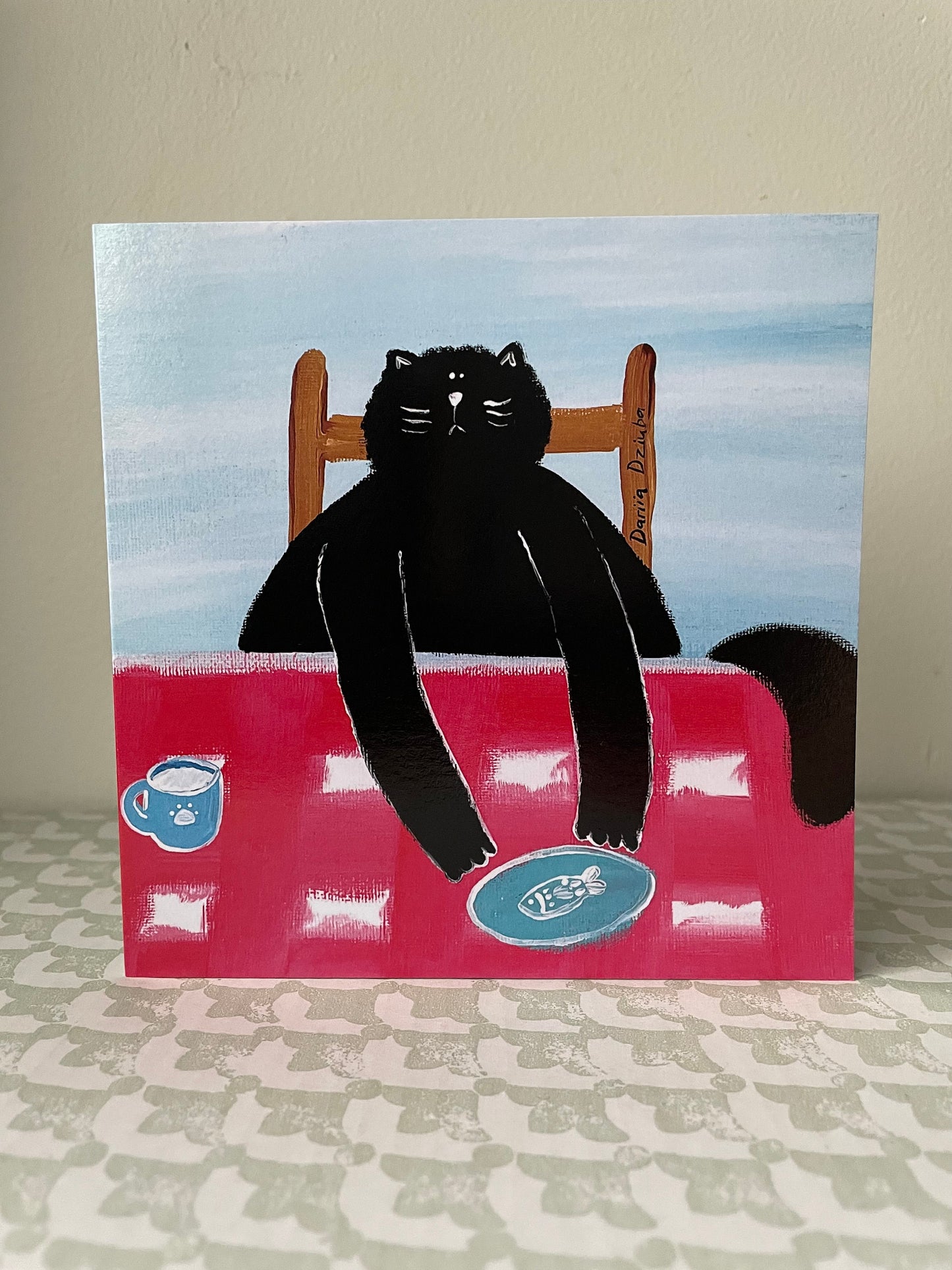 Black cat at a table: Greeting card